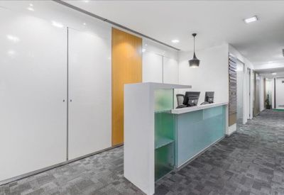 Professional reception area with a frosted glass front desk and warm wood wall paneling.