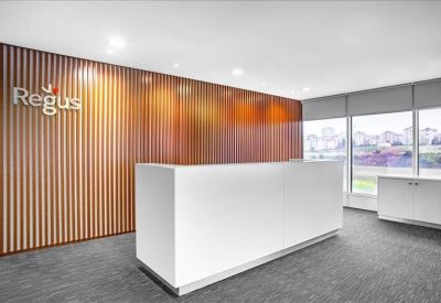 Bright reception area featuring a white desk and a warm wood-slatted feature wall.