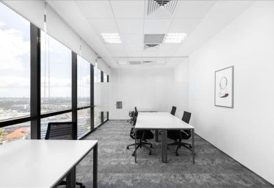 Long meeting table in a bright, white office with panoramic urban views.