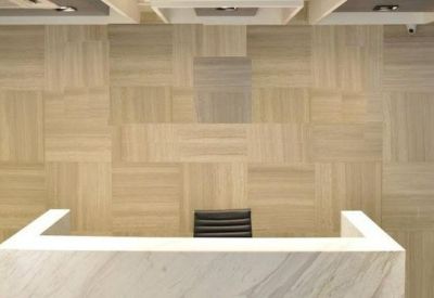 Reception area with a marble desk and patterned wall.