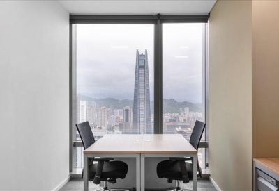 Two-person private office suite with large windows showing a skyscraper view.