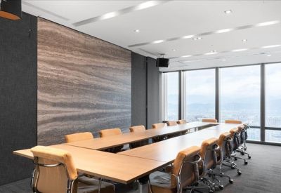 Spacious boardroom with a long wooden table and panoramic windows overlooking the city.