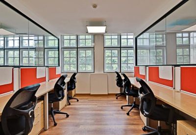 Open-plan office desks with bright red privacy screens.