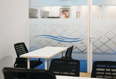 Small three-person glass-walled office suite with a frosted wave pattern on the door.