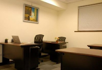 Private office space with two dark wood desks and black ergonomic mesh chairs.