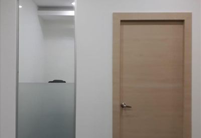 Wooden office entrance door alongside a frosted glass partition panel.