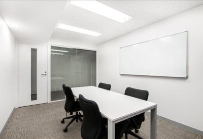 Bright white meeting room with rectangular table and black seating.