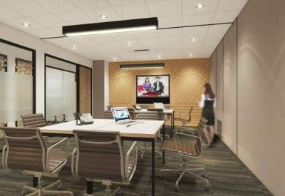 Bright conference room with a white table, video conferencing screen, and ergonomic chairs.