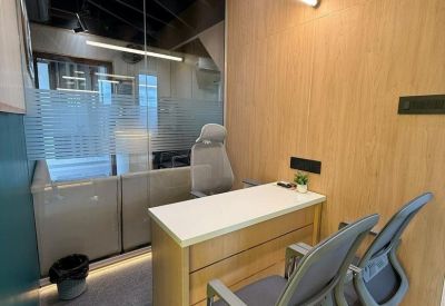 Internal two-person office at Suvidhi Signature with wooden paneling and glass partitions.