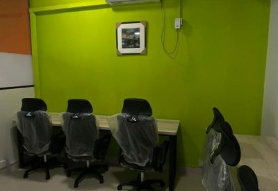 Workstation row featuring a bright lime green wall and air conditioning unit.
