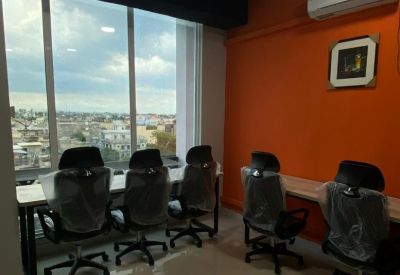 Bright office with individual workstations near a window overlooking the city.