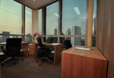 Private office suite with wooden desks and expansive city views through floor-to-ceiling windows.