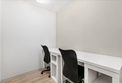 Bright private office suite with white desks and black mesh chairs.