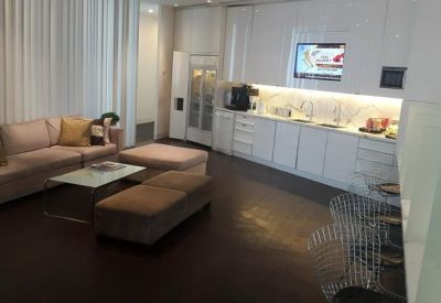 Modern office breakout area with a fully-equipped kitchen, plush sofa, and lounge seating.
