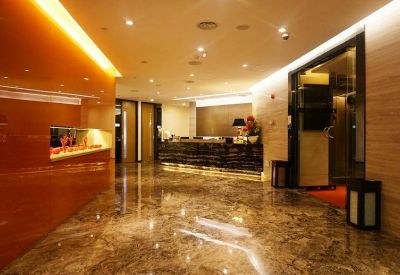 Polished marble reception lobby with a sleek dark front desk and warm ambient lighting.