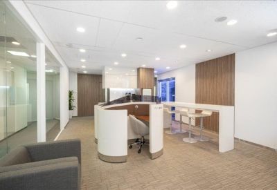 Open communal area featuring a rounded white workstation and a high-top breakfast bar.