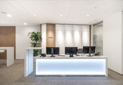 Modern reception desk with backlit front panel and sleek desktop monitors.