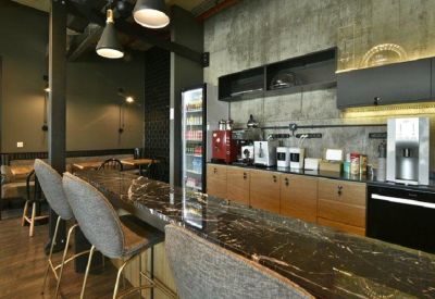 Industrial-style kitchen area with a dark marble breakfast bar and pendant lighting.