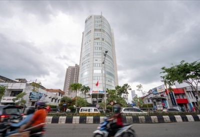 Exterior view of the curved glass facade of Panin Tower (L8) under a cloudy sky.