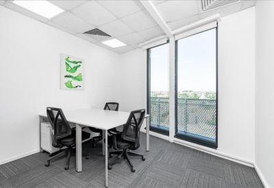 Bright private office with a white table and large windows.