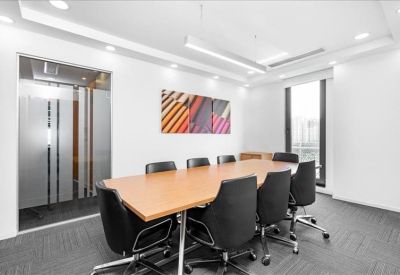 Professional meeting room featuring a long wooden table and modern artwork.