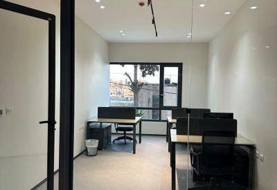 Internal glass-walled office suite with multiple desks.