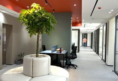 Lounge area with a circular white sofa and a bold red ceiling.