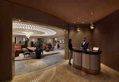 Sophisticated reception desk with dark wood finishes and warm pendant lighting.