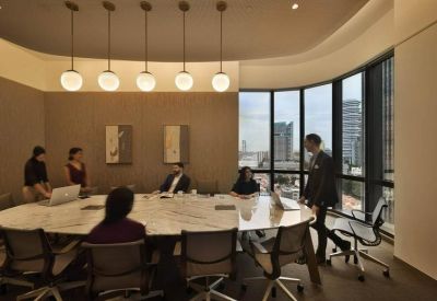 Bright conference room with a marble table, hanging globe lights, and floor-to-ceiling city views.