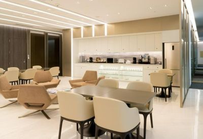 Spacious communal lounge and kitchen area with warm lighting and comfortable cafe-style seating.