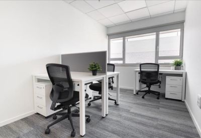Bright private office suite with two workstations and window views.