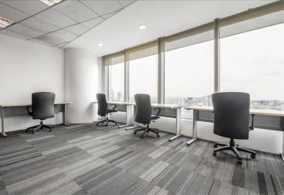Bright corner office space with individual desks and floor-to-ceiling windows.
