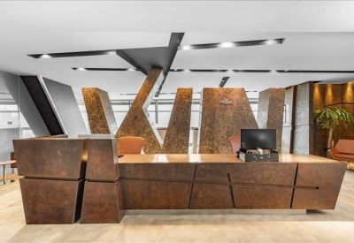 Spacious reception desk with bold, rusted-metal textures and modern overhead lighting.