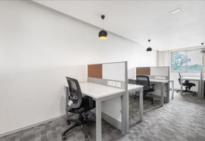 Bright open-plan workspace with multiple desks, ergonomic chairs, and pendant lighting.
