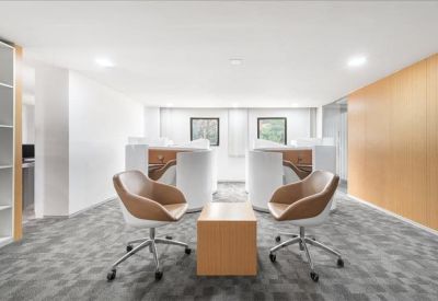 Modern breakout area with stylish armchairs and a minimalist wood coffee table.