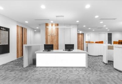 Spacious reception area featuring a clean white desk and wooden wall accents.