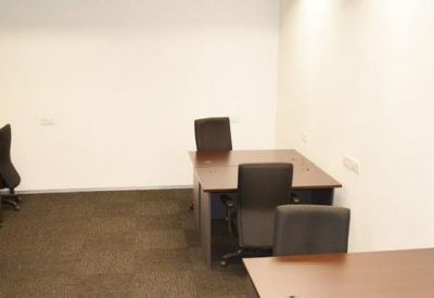 Internal office suite featuring four dark wood desks and black ergonomic chairs.