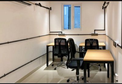 Four-person internal office suite with wood-topped desks and black mesh chairs.