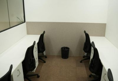 Small two-person office suite with white desks and black mesh chairs.