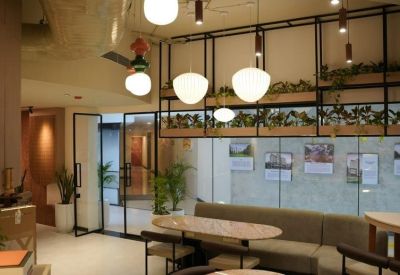 Spacious communal lounge with plush seating, warm lighting, and decorative indoor plants.