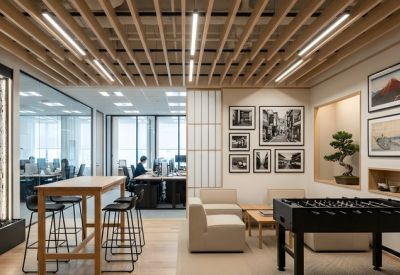 Vibrant communal breakout space with a foosball table, lounge seating, and a decorative slatted wood ceiling.