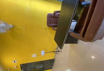 Private office corner featuring a dark wooden desk and a comfortable brown leather chair.