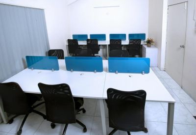 Private office workspace with white desks separated by blue privacy screens.
