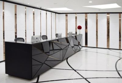 Modern black geometric reception desk in a bright lobby.