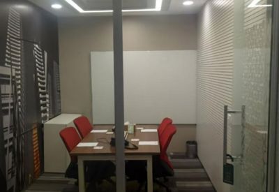 Small meeting room with a wooden table, red chairs, and a whiteboard.