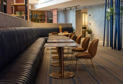 Long communal dining area with navy booth seating and marble tables.