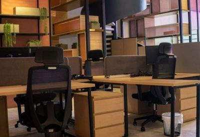 Open-plan office area with timber desks and modern shelving units.