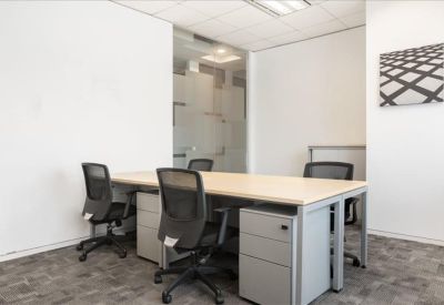 Bright private four-person office suite with light wood desks.