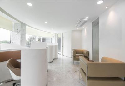 Bright breakout area with modern curved seating and white marble-style flooring.