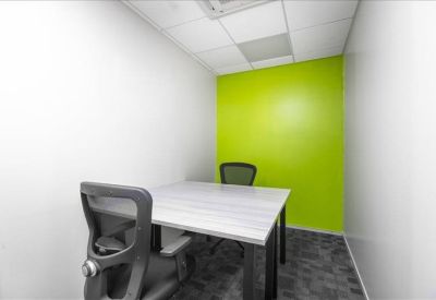 Small meeting room featuring a lime green accent wall and light grey table.